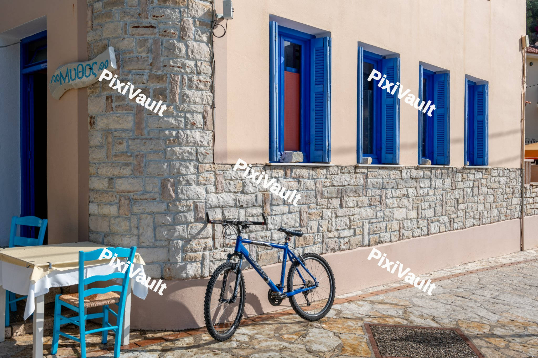 Blue bicycle in front of a stone house